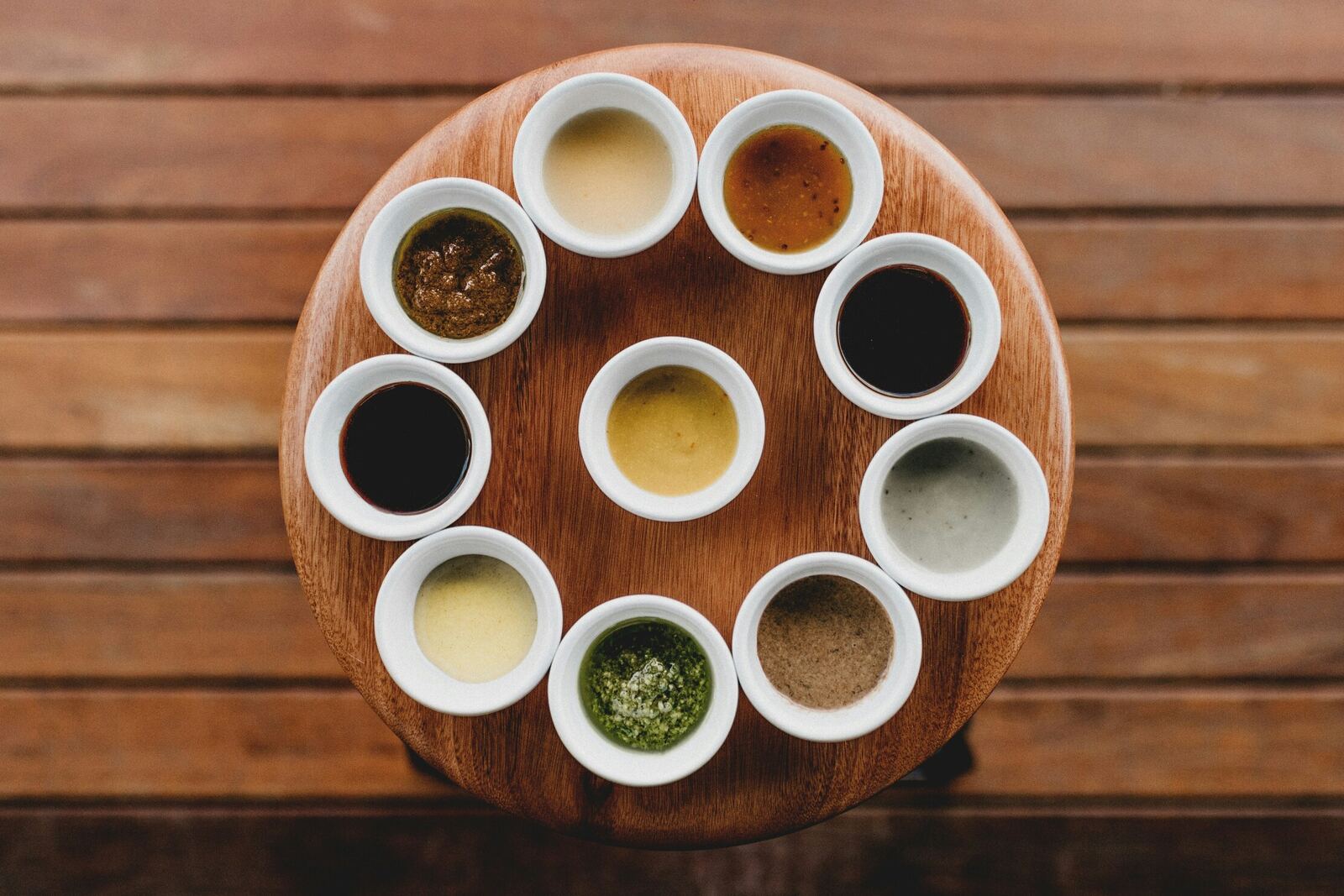 Assortment of sauces and dips in small bowls on a wooden board